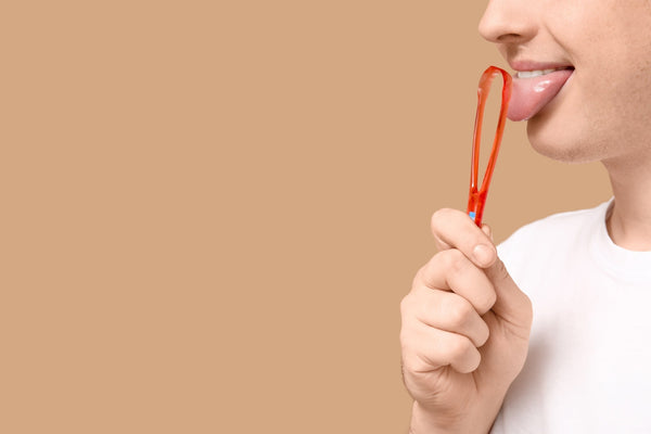 Man uses a tongue cleaner to get rid of bad breath
